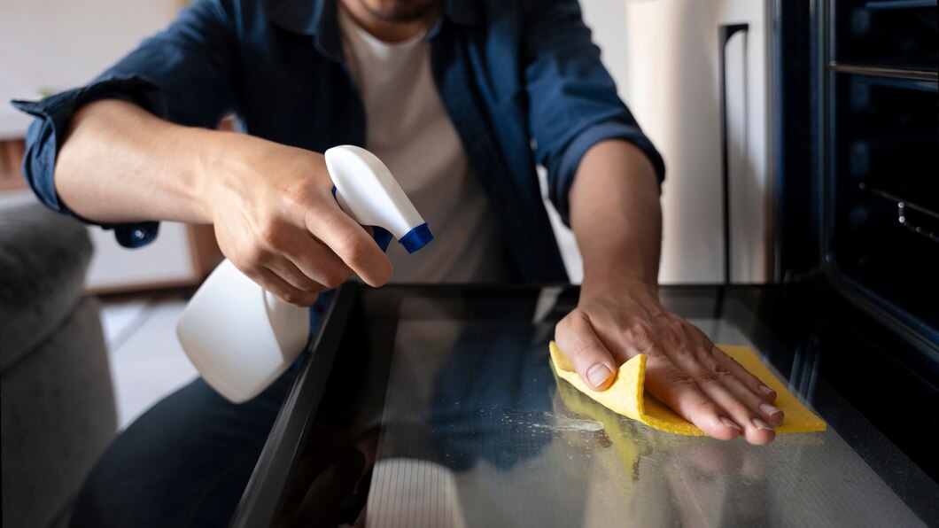 Homem limpando gordura na cozinha.